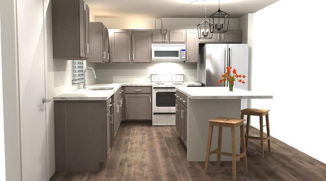 kitchen with sink, stainless steel appliances, dark hardwood / wood-style floors, pendant lighting, and a breakfast bar area