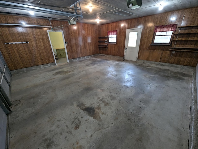 garage with wood walls and a garage door opener