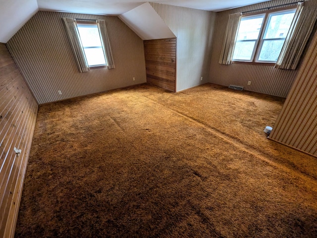 additional living space with carpet flooring and lofted ceiling