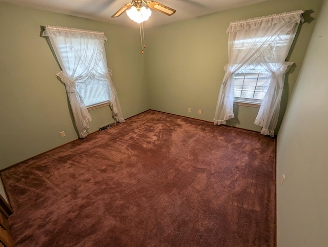 carpeted spare room featuring ceiling fan