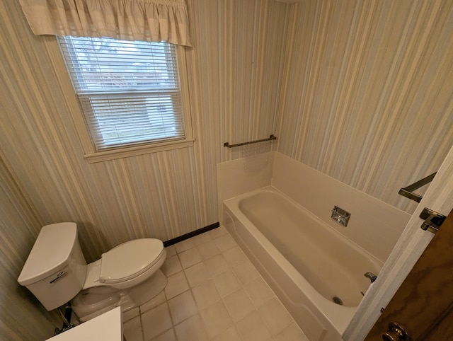 bathroom with tile patterned flooring, toilet, and a bath