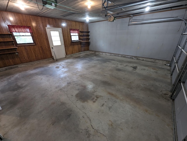 garage with a garage door opener and wooden walls