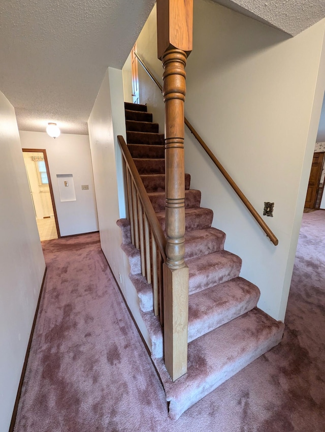 stairs with carpet flooring and a textured ceiling