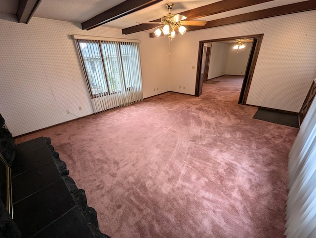 carpeted spare room with beamed ceiling and ceiling fan