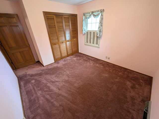 unfurnished bedroom featuring carpet and a closet