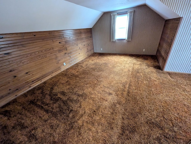 bonus room with wooden walls, carpet floors, and lofted ceiling