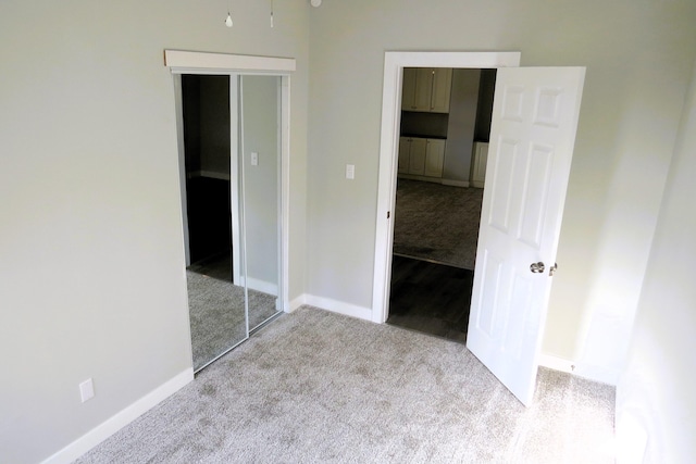 unfurnished bedroom featuring light colored carpet and a closet