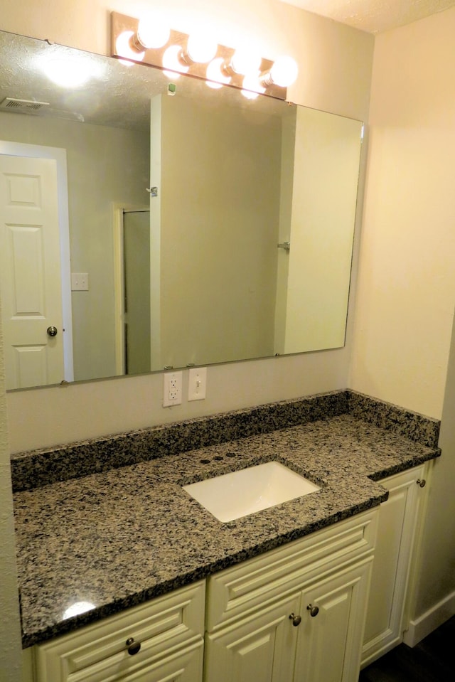 bathroom with vanity and a textured ceiling