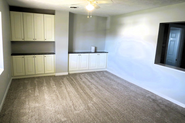 carpeted empty room featuring a textured ceiling and ceiling fan