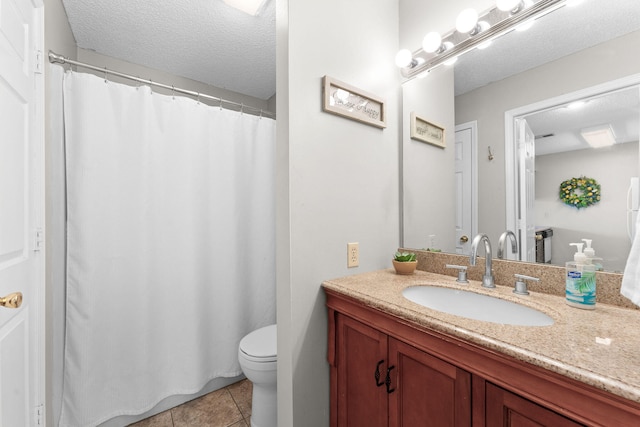 bathroom featuring tile patterned flooring, vanity, a textured ceiling, and toilet