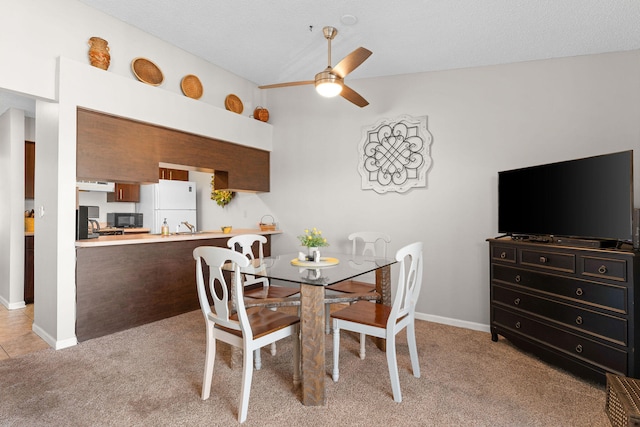 carpeted dining space with a textured ceiling and ceiling fan