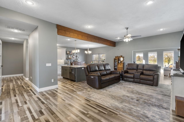 living room with a healthy amount of sunlight, ceiling fan with notable chandelier, and light wood-type flooring