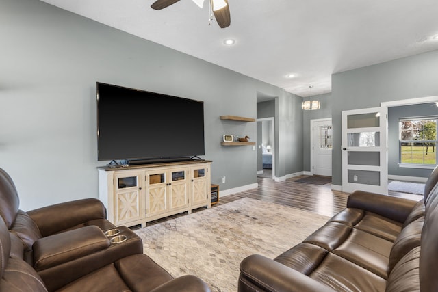 living room featuring hardwood / wood-style floors and ceiling fan with notable chandelier