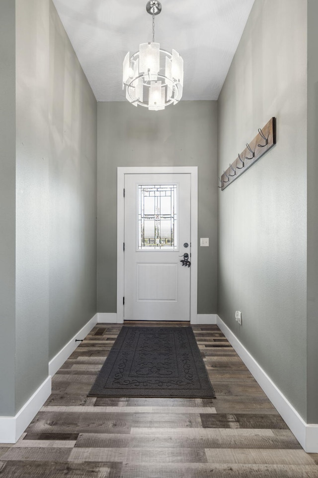 doorway featuring a chandelier and dark wood-type flooring