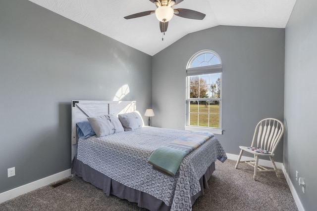 bedroom with dark colored carpet, vaulted ceiling, and ceiling fan