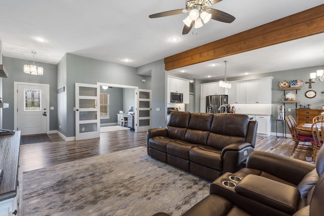 living room with dark hardwood / wood-style floors and ceiling fan with notable chandelier