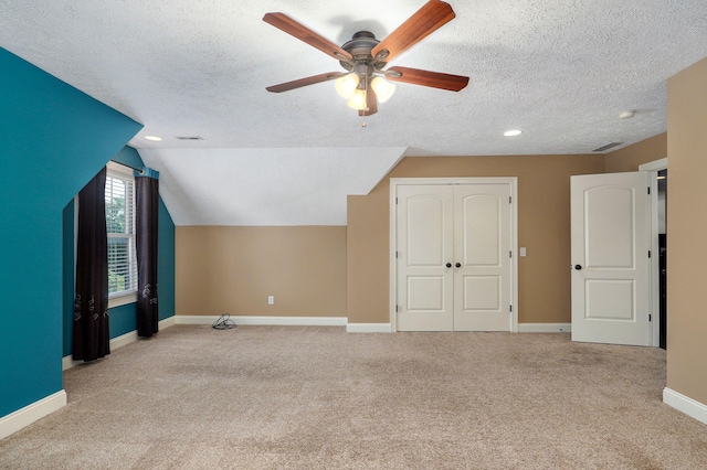 bonus room with ceiling fan, light colored carpet, a textured ceiling, and vaulted ceiling