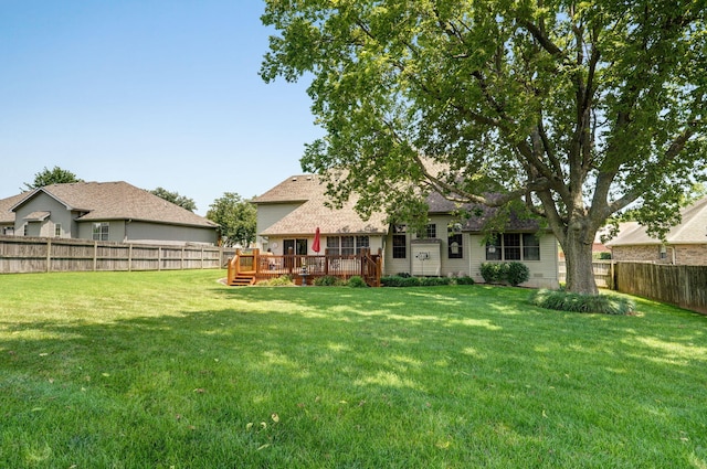 rear view of house featuring a lawn and a deck