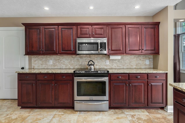 kitchen featuring a textured ceiling, decorative backsplash, light stone countertops, and stainless steel appliances