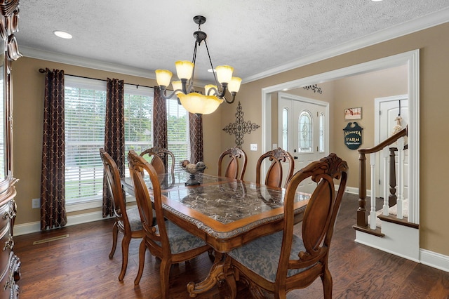 dining room featuring a textured ceiling, ornamental molding, dark wood-type flooring, and an inviting chandelier