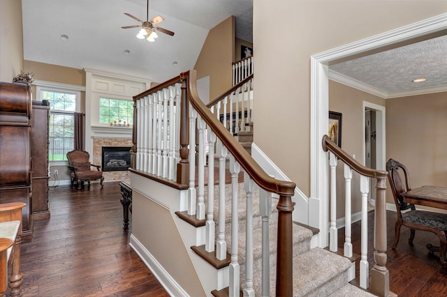 stairway featuring a textured ceiling, ceiling fan, wood-type flooring, and ornamental molding