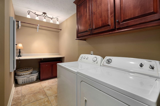 laundry room with washer and dryer, cabinets, and a textured ceiling