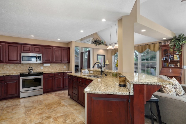 kitchen featuring a large island, lofted ceiling, sink, and appliances with stainless steel finishes