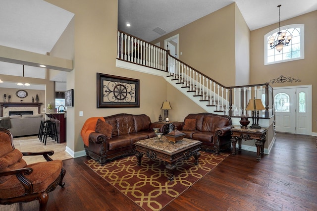 living room featuring hardwood / wood-style floors, a high ceiling, and a chandelier