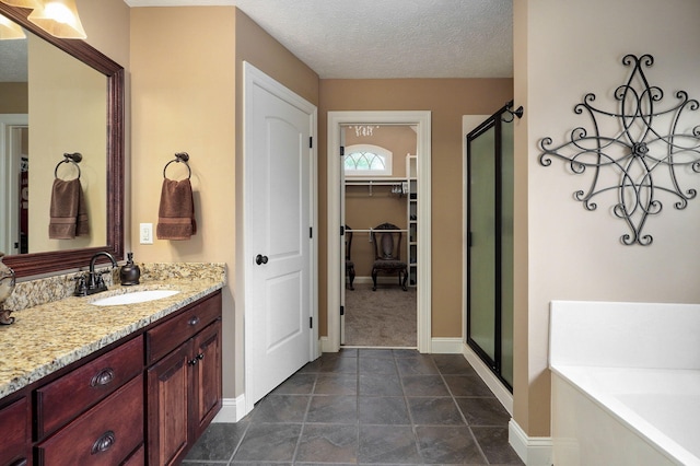 bathroom featuring vanity, independent shower and bath, and a textured ceiling