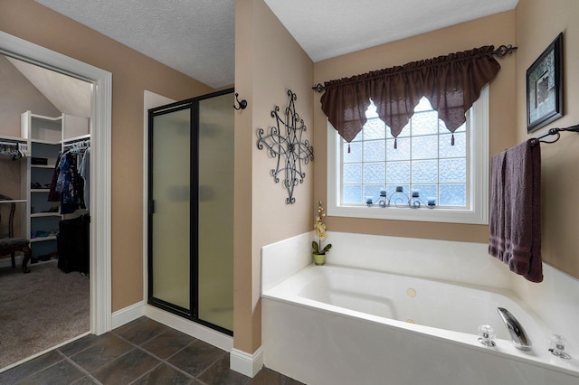 bathroom featuring a textured ceiling, tile patterned flooring, and shower with separate bathtub