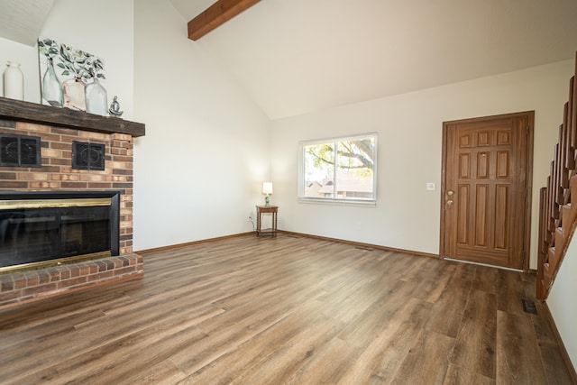 unfurnished living room featuring a fireplace, hardwood / wood-style floors, high vaulted ceiling, and beam ceiling