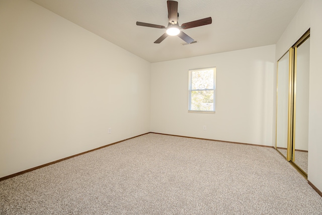 unfurnished bedroom with carpet, a closet, and ceiling fan