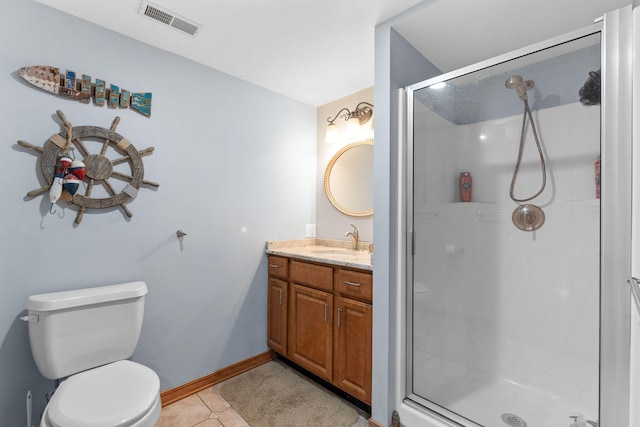 bathroom featuring tile patterned flooring, vanity, a shower with shower door, and toilet