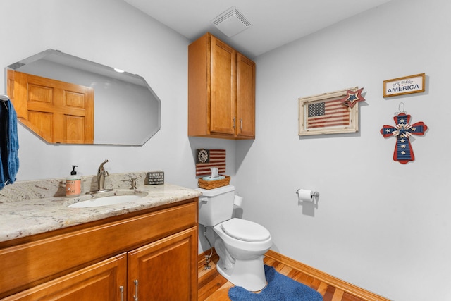 bathroom with hardwood / wood-style floors, vanity, and toilet