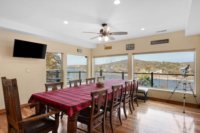 dining space with ceiling fan, a mountain view, and hardwood / wood-style flooring