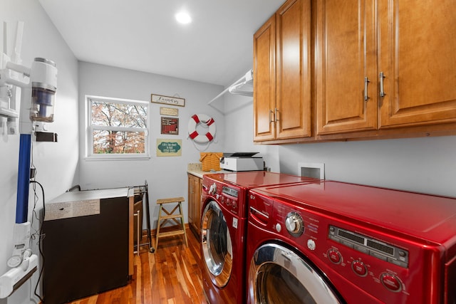 laundry room featuring cabinets, wood-type flooring, and independent washer and dryer