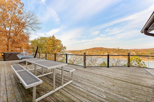 deck featuring a water and mountain view and a hot tub