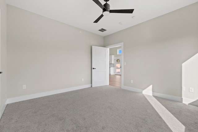 carpeted spare room featuring ceiling fan