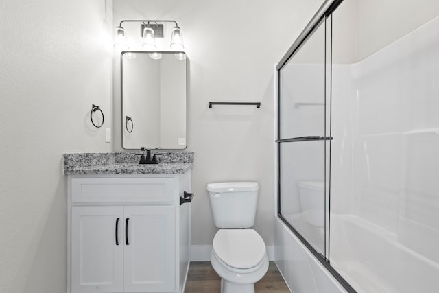 full bathroom with hardwood / wood-style floors, vanity, toilet, and shower / bath combination with glass door