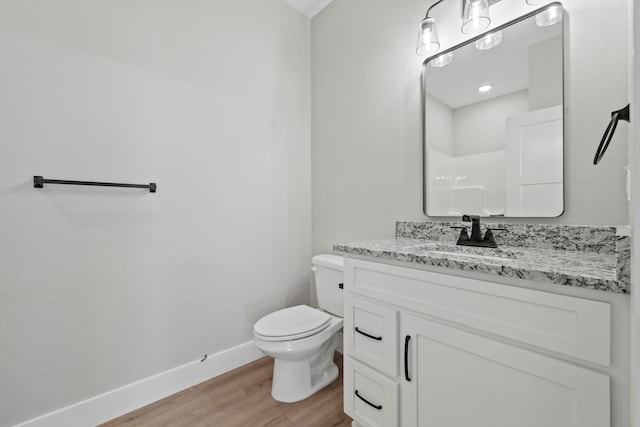 bathroom featuring wood-type flooring, vanity, and toilet