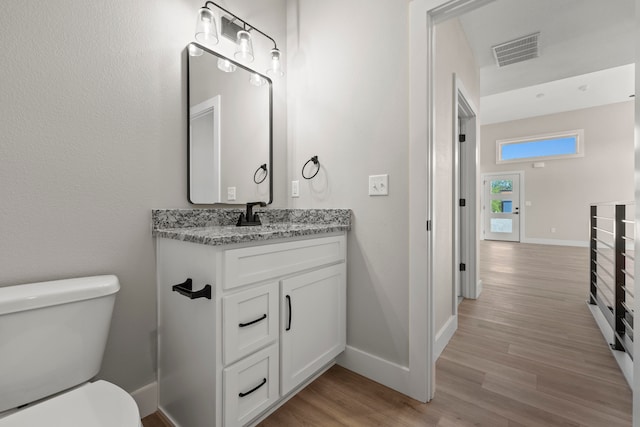 bathroom featuring hardwood / wood-style floors, vanity, and toilet