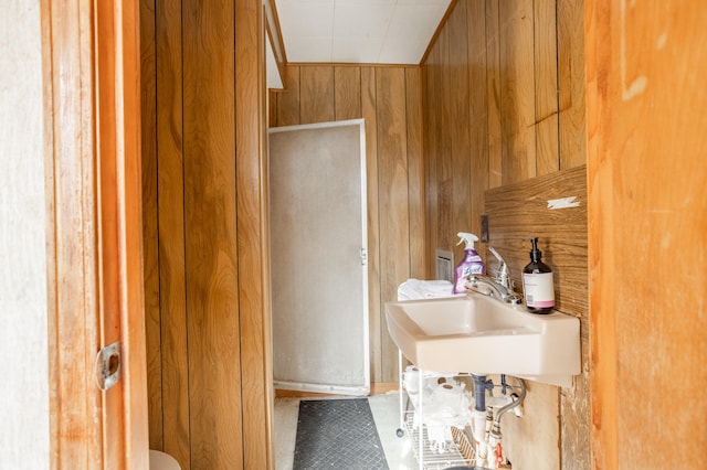 bathroom featuring sink and wood walls