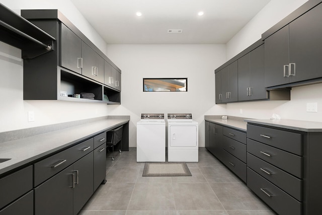 laundry room with light tile patterned flooring, cabinets, and separate washer and dryer