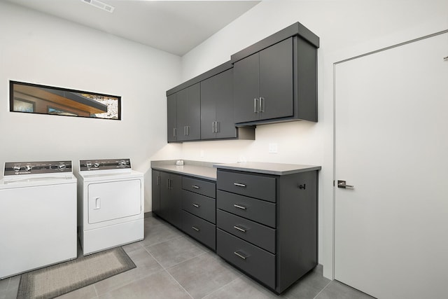 laundry room featuring cabinets, washer and clothes dryer, and light tile patterned flooring