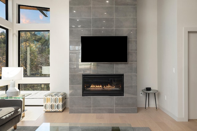 living room featuring a tile fireplace and hardwood / wood-style floors