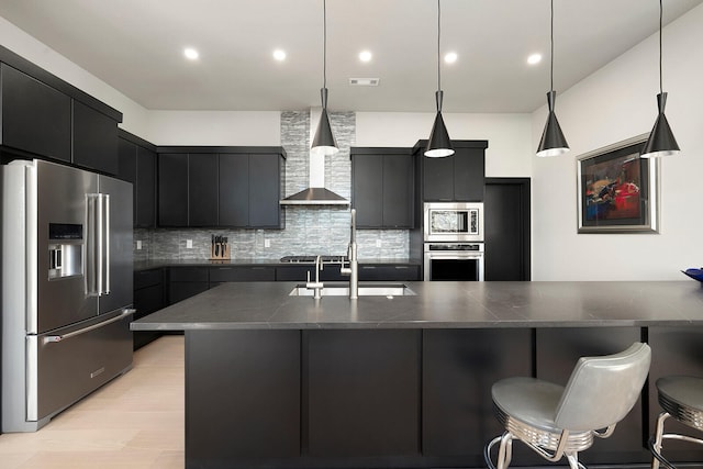 kitchen featuring appliances with stainless steel finishes, backsplash, decorative light fixtures, and wall chimney exhaust hood