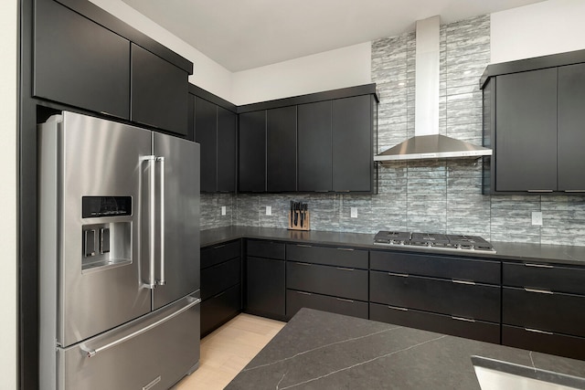 kitchen featuring wall chimney exhaust hood, decorative backsplash, and appliances with stainless steel finishes