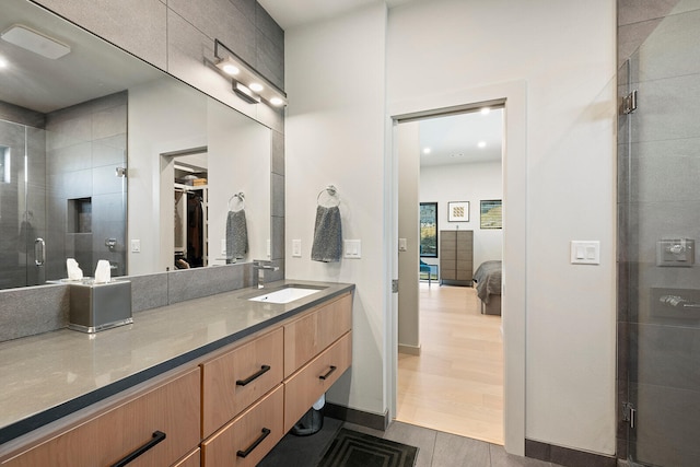 bathroom with hardwood / wood-style floors, vanity, and walk in shower