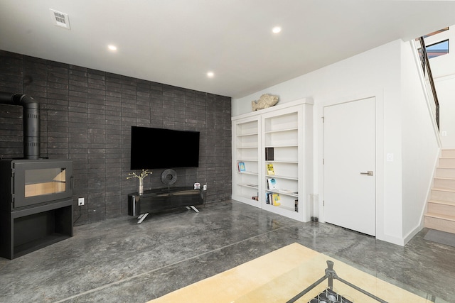 living room with a wood stove and built in shelves