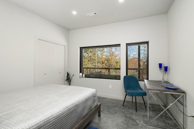 bedroom with concrete floors and a closet